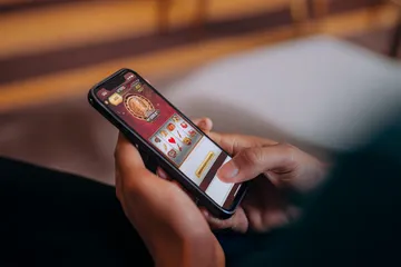 A cheerful woman in traditional clothing using her smartphone during a festive moment, showing how easily the JILI7979 app fits into everyday life.