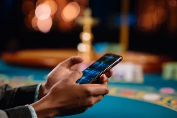 A player using their smartphone during a festive local event, representing JILI7979’s fully mobile-friendly casino.